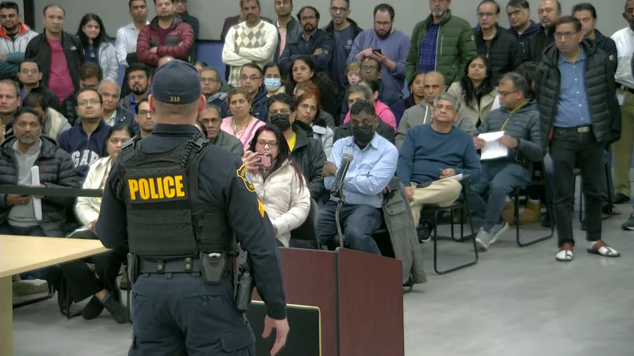 A police officer addresses the audience to maintain order after the vote on the motion to table O.2211-2024 was disrupted by angry residents in the council chambers on Feb. 28, 2024. EDISON TV/Livestream